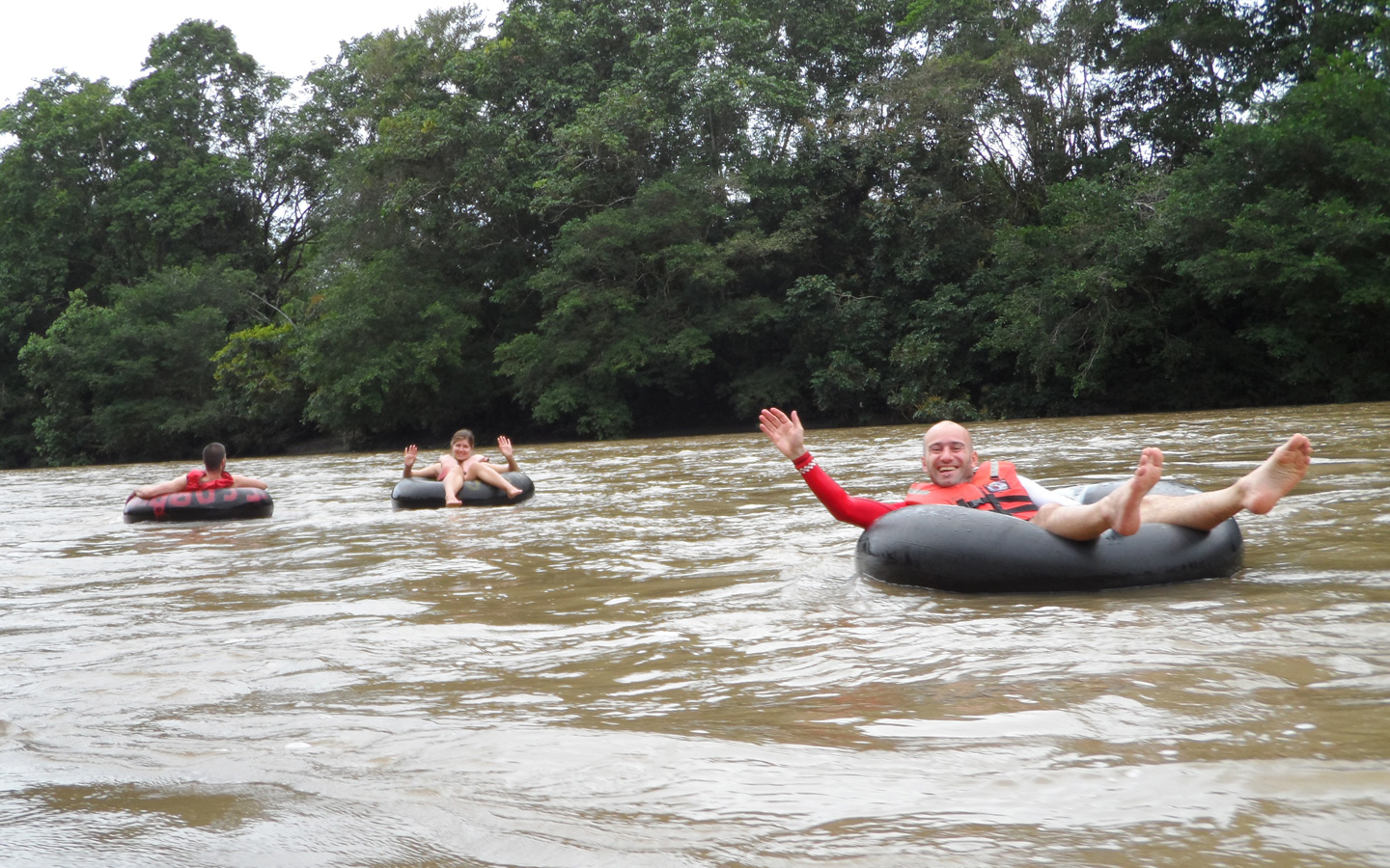 Two Spanish students waving during a tubing activity in Mindo