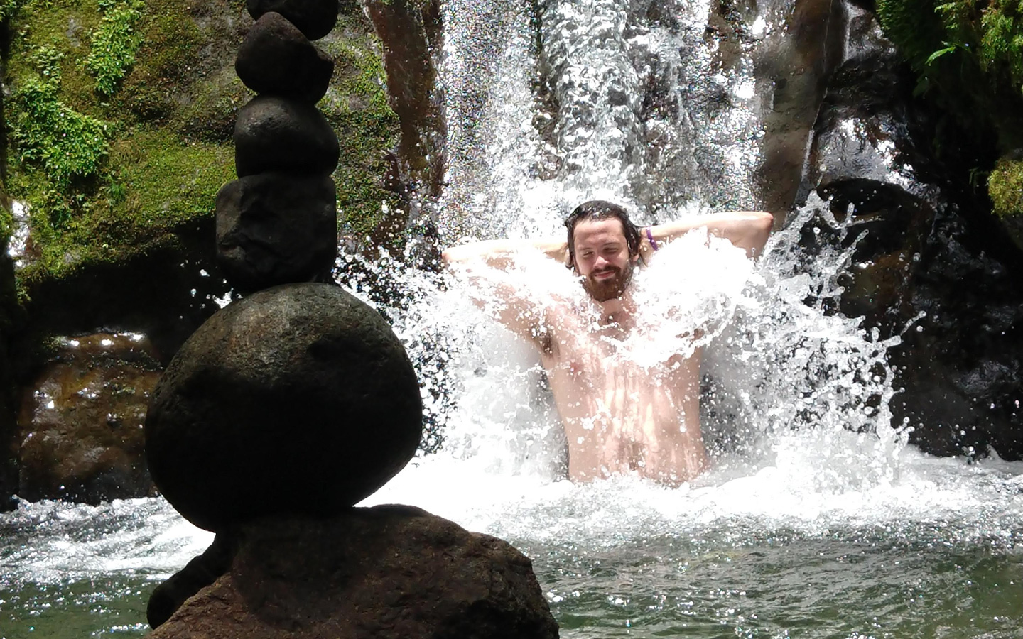A Spanish student enjoying the cold water of a waterfall during a weekend excursion to Mindo